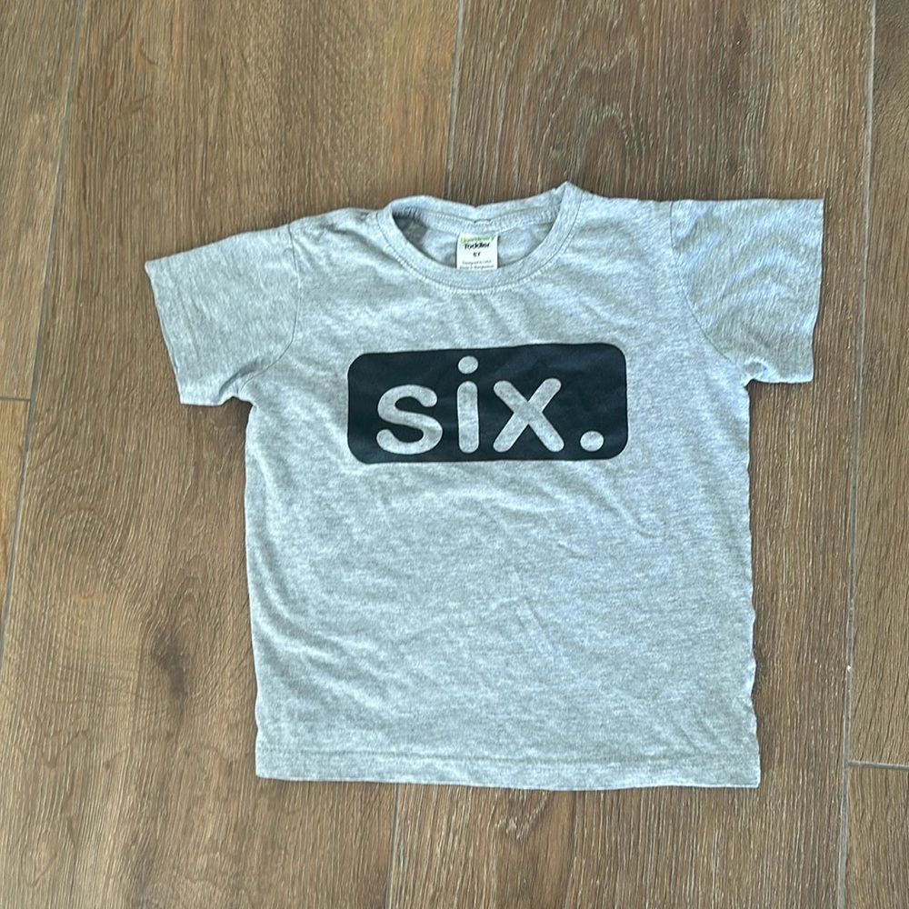 In ordinary boys short sleeve t-shirt. Size 6. Color grey with black/grey 6.